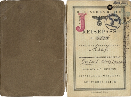 Two pages of a passport . The passport’s first page, on the right, is stamped with a red "J" and date 1/1/1939, and a circular ink stamp from the Police President of Hamburg and another green circular ink stamp. There is handwriting along the border of the page.