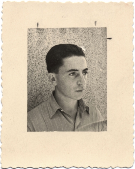 Black-and-white photograph with a large white border of a young man looking towards the right of the camera. His hair is combed back and he wears a collared shirt.