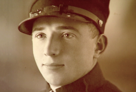 Photo de couleur sépia d'un gros plan du visage d'un homme. L'homme regarde à gauche de la caméra et porte ce qui semble être un uniforme militaire.