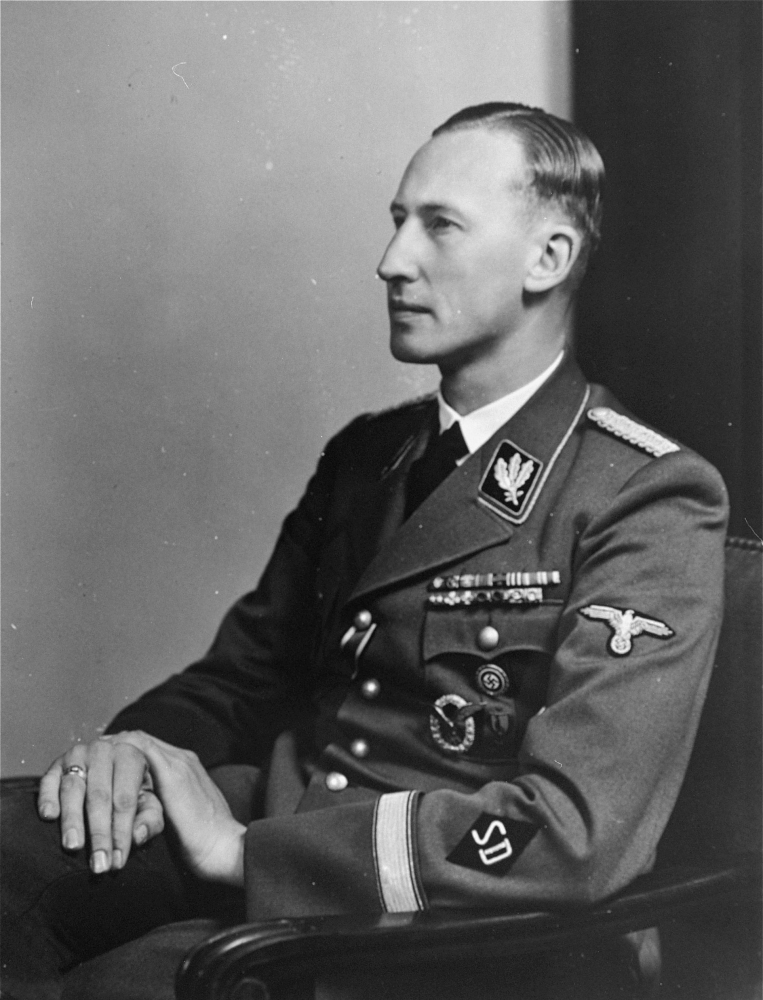 Black-and-white portrait photograph of a man looking towards the left of the camera, visible from his waist up, wearing a military suit.