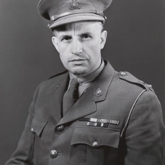 Portrait photographique en noir et blanc d'un homme, pris de la taille, portant un uniforme militaire.