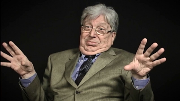 Screenshot of Holocaust survivor Paul Herczeg video testimony. He is sitting in front of a black background, and looking to the left of the camera. The camera shows his face and shoulders.