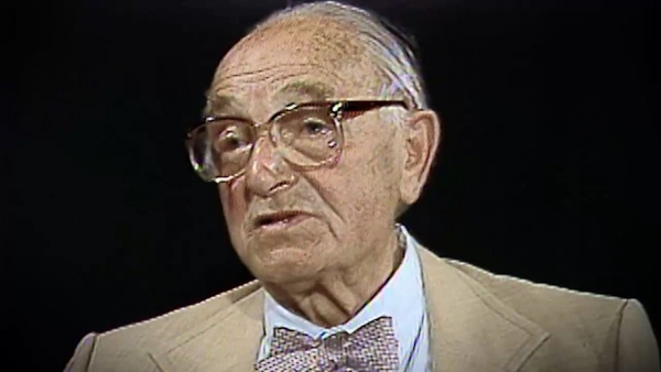 Screenshot of Holocaust survivor Joseph Klinghoffer video testimony. He is sitting in front of a black background, and looking to the left of the camera. The camera shows his face and shoulders.