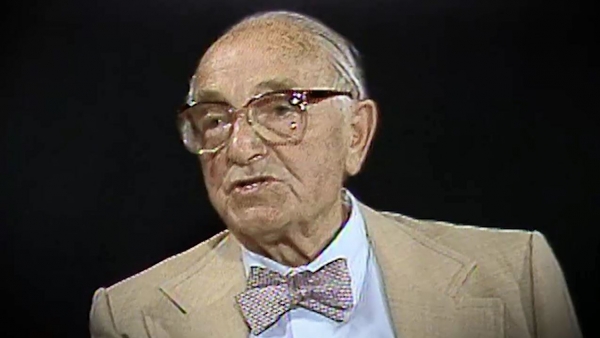 Screenshot of Holocaust survivor Joseph Klinghoffer video testimony. He is sitting in front of a black background, and looking to the left of the camera. The camera shows his face and shoulders.