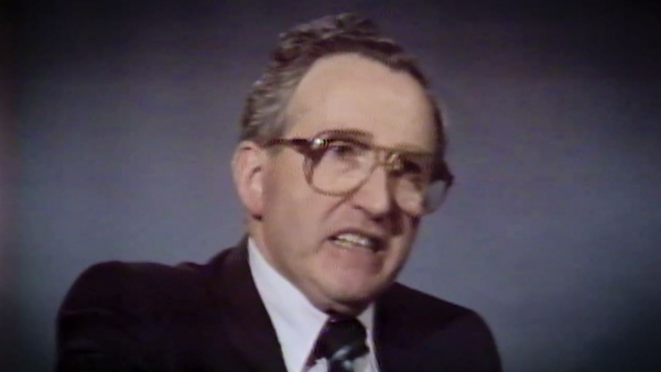 Screenshot of Holocaust survivor Moishe Kantorowitz video testimony. He is sitting in front of a dark background, and looking to the left of the camera. The camera shows his face and shoulders.