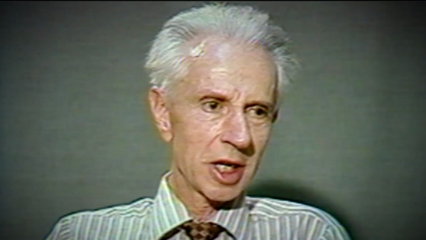 Screenshot of  Holocaust survivor Stefan Carter video testimony. He is sitting in front of a dark background and looks to the right of the camera. The camera shows his face and shoulders.